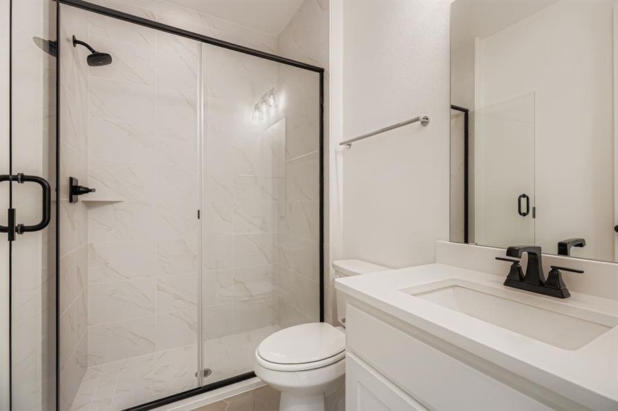 Bathroom with vanity and a marble finish shower