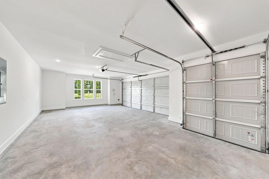 Spacious garage with a dedicated golf cart garage, offering plenty of room for vehicles, golf cart parking, storage, and added flexibility.