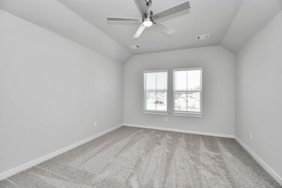 Secondary bedroom features plush carpeting, large windows that let in plenty of natural light, bright paint, and spacious closets. Sample photo of completed home with similar floor plan. Actual colors and selections may vary.
