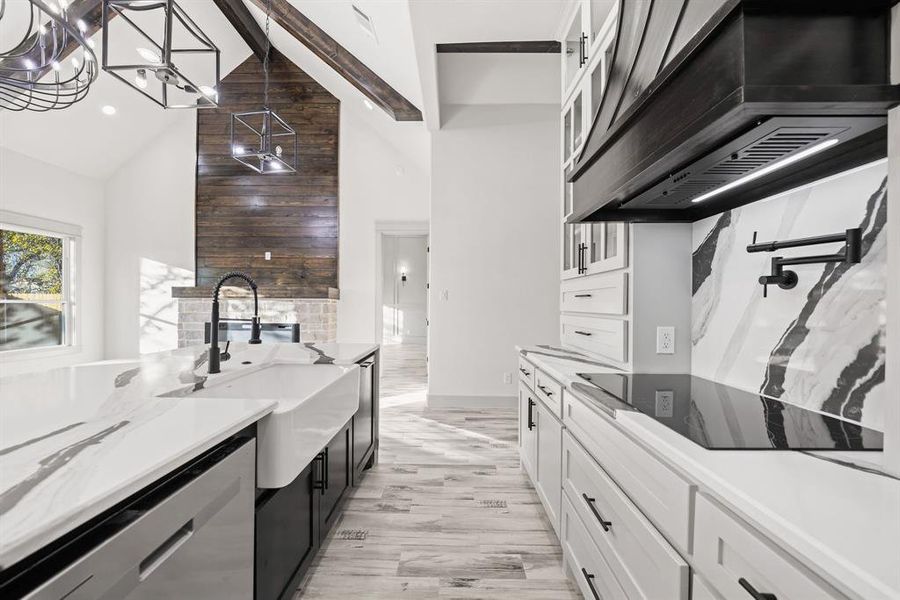 Kitchen with dark cabinets, white cabinetry, custom exhaust hood, stainless steel dishwasher, and beam ceiling Kitchen with dark cabinets, white cabinetry, custom exhaust hood, stainless steel dishwasher, and beam ceiling