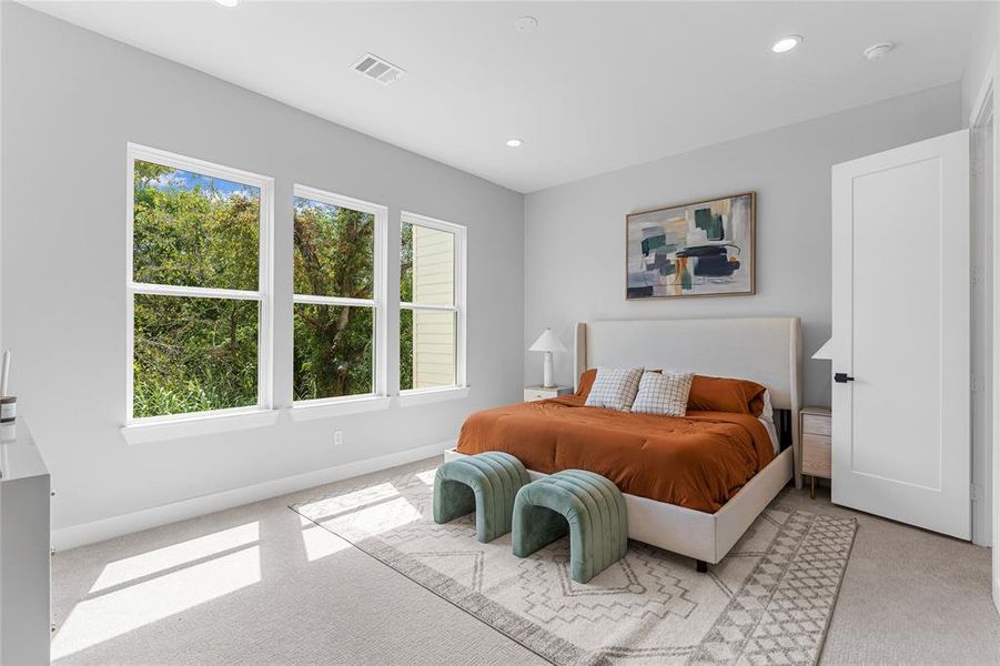 The oversized primary bedroom, adorned with three large windows, illuminates the space effortlessly, making artificial lighting almost redundant.