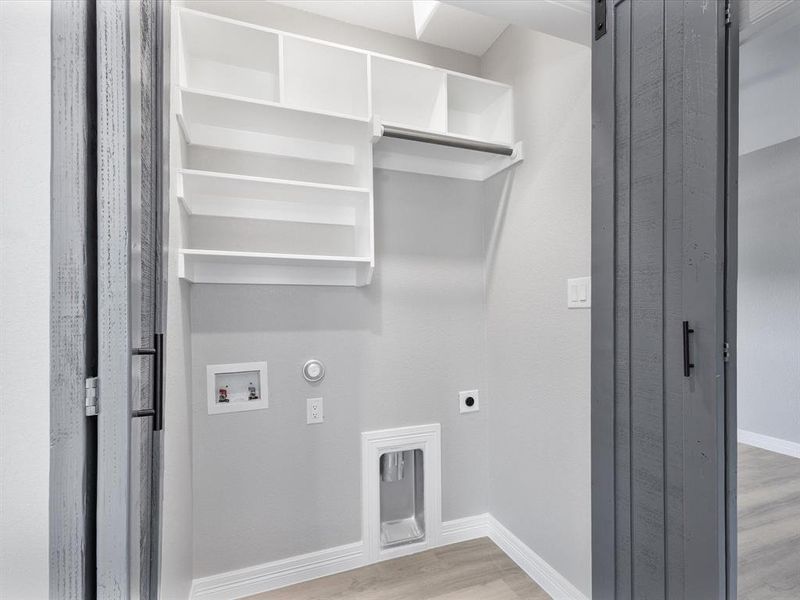 Laundry area with hookup for an electric dryer, hookup for a gas dryer, hookup for a washing machine, light wood-style flooring, and baseboards Laundry area with hookup for an electric dryer, hookup for a gas dryer, hookup for a washing machine, light wood-style flooring, and baseboards
