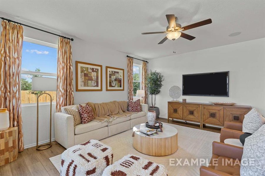 Living room with light hardwood / wood-style floors and ceiling fan