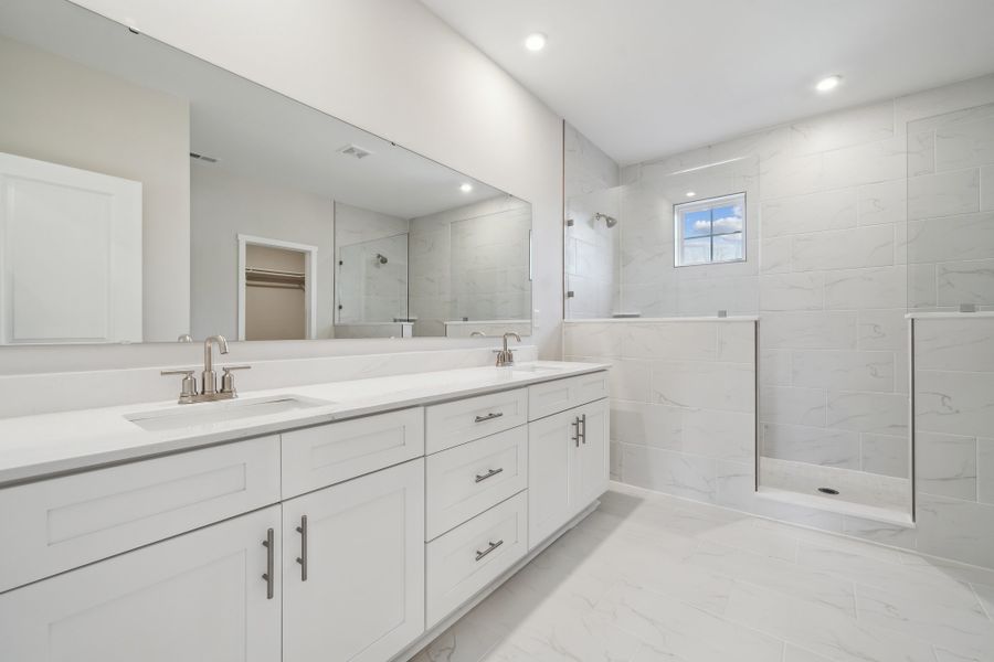A bathroom with white cabinets.