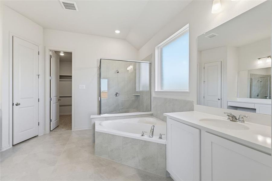 Bathroom featuring a bath, a shower stall, a spacious closet, vanity, and recessed lighting Bathroom featuring a bath, a shower stall, a spacious closet, vanity, and recessed lighting
