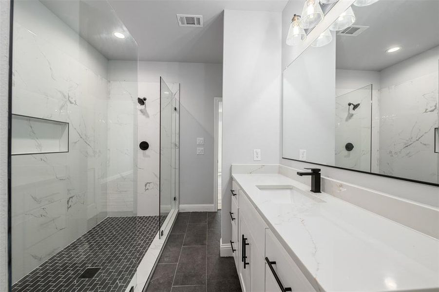 Full bathroom with a marble finish shower, vanity, recessed lighting, and tile patterned floors Full bathroom with a marble finish shower, vanity, recessed lighting, and tile patterned floors