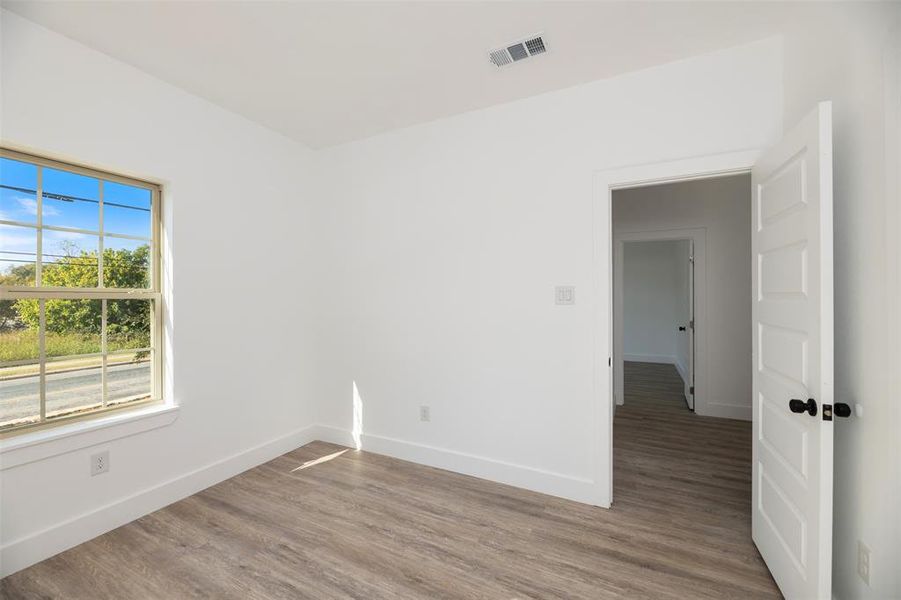 Spare room featuring wood finished floors and baseboards Spare room featuring wood finished floors and baseboards