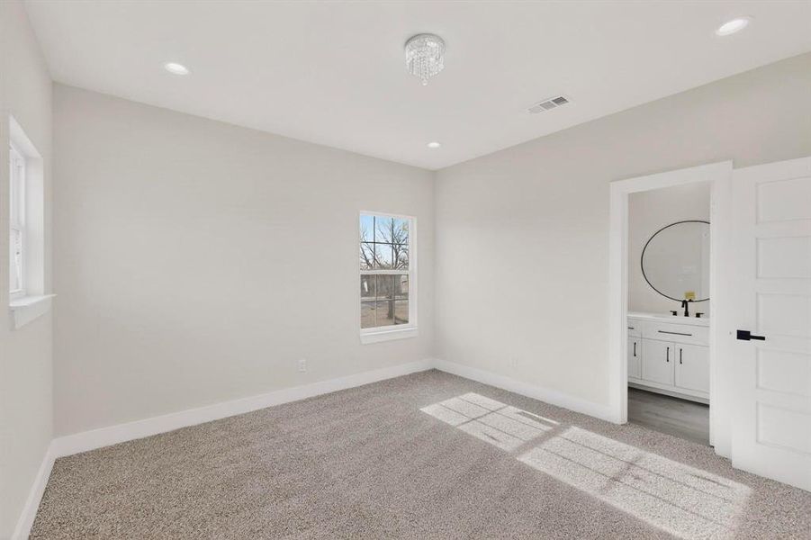Bedroom with light colored carpet, ensuite bathroom, and recessed lighting Bedroom with light colored carpet, ensuite bathroom, and recessed lighting