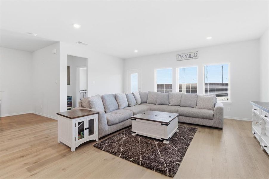 Living area with light wood finished floors and recessed lighting Living area with light wood finished floors and recessed lighting