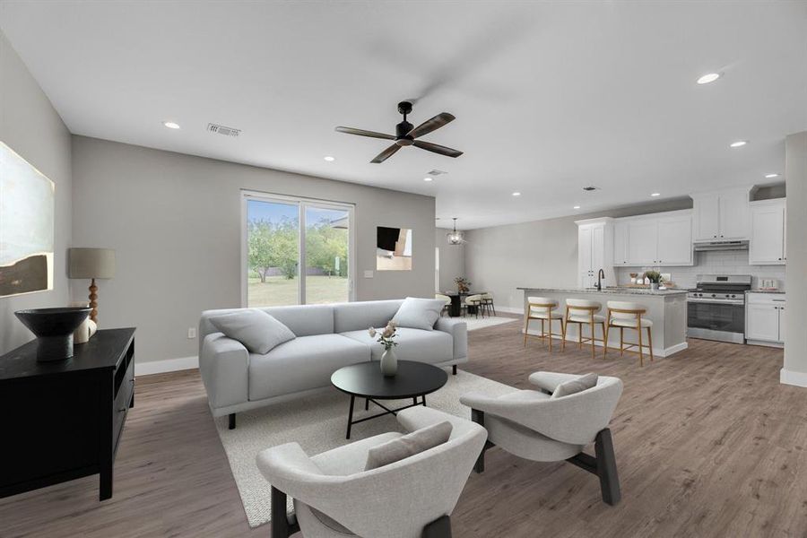 Living area with light wood-style floors, ceiling fan, and recessed lighting