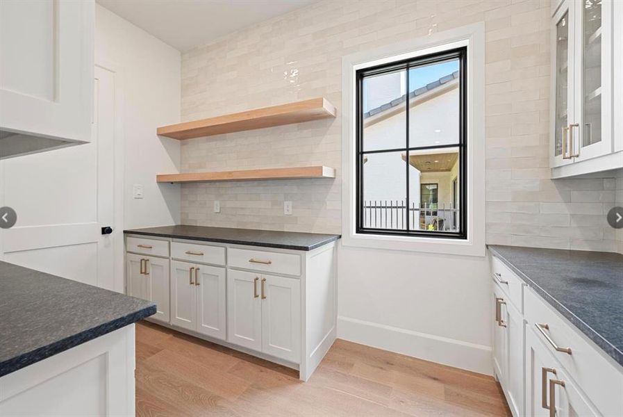 Kitchen featuring white cabinetry, tasteful backsplash, and light hardwood / wood-style floors