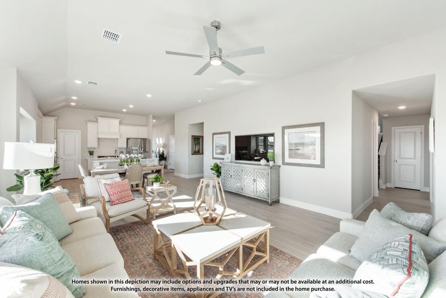 Open-concept living room with ceiling fan and hardwood floors, open to kitchen and dining area beyond Open-concept living room with ceiling fan and hardwood floors, open to kitchen and dining area beyond