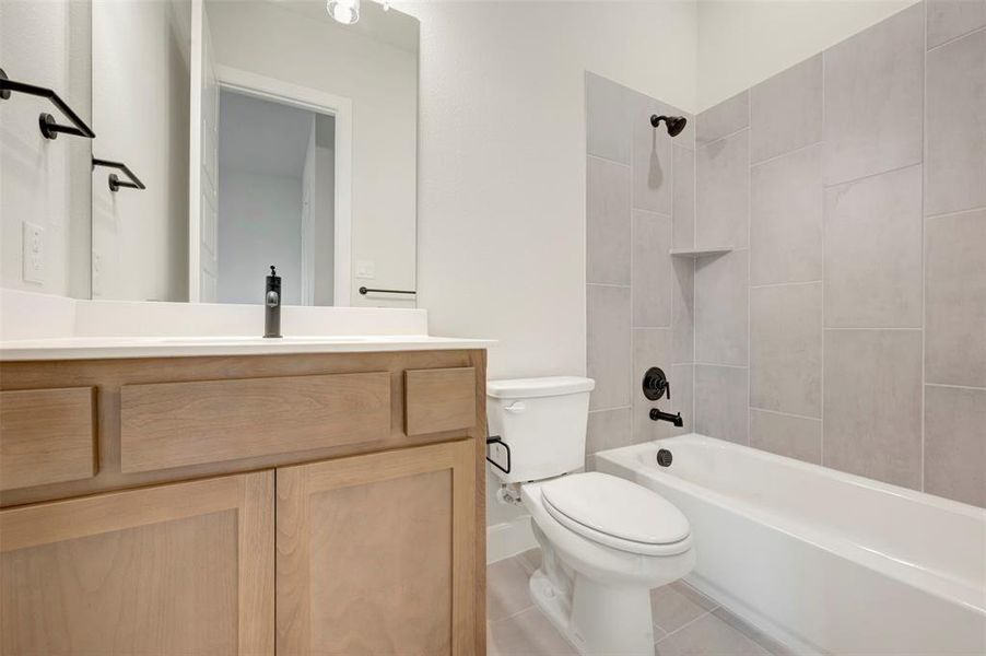 Bathroom featuring vanity, tub / shower combination, and light tile patterned flooring