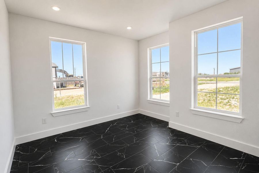 Three generous windows illuminate this versatile space, perfect for any need.