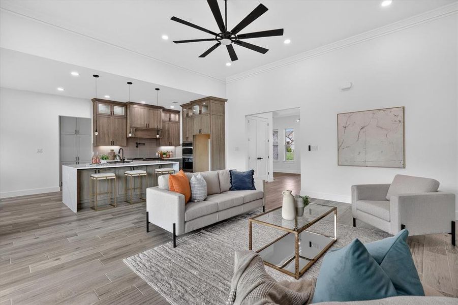 Living area with light wood-style flooring, ceiling fan, crown molding, and recessed lighting