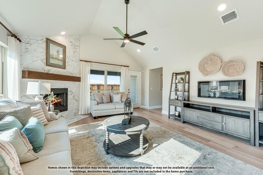 Living room with vaulted ceiling, marble tile fireplace, ceiling fan, and hardwood floors Living room with vaulted ceiling, marble tile fireplace, ceiling fan, and hardwood floors