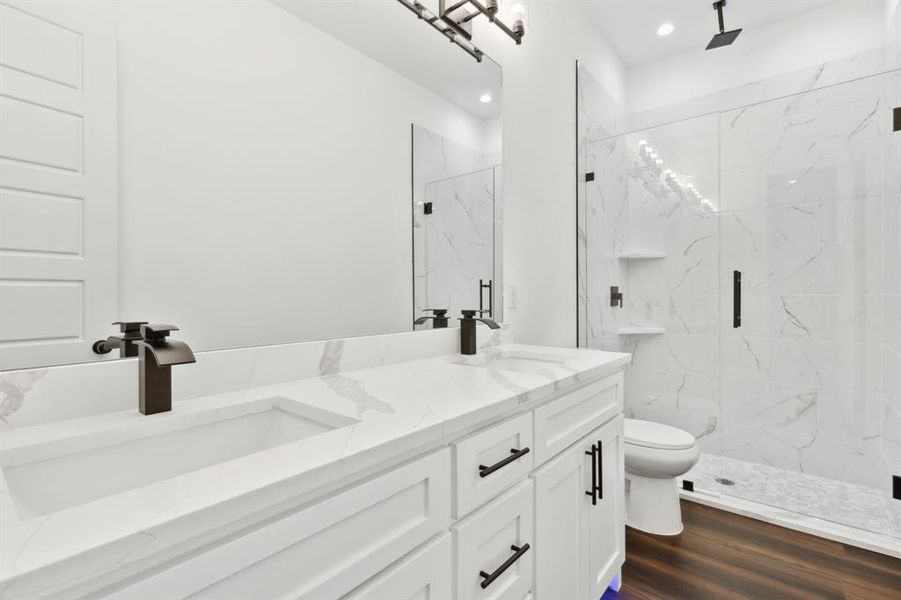 Bathroom featuring an enclosed shower, hardwood / wood-style flooring, vanity, and toilet