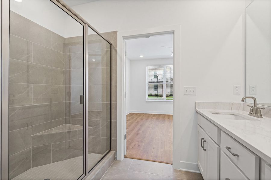Glass-enclosed shower featuring large format tile and an integrated bench seat