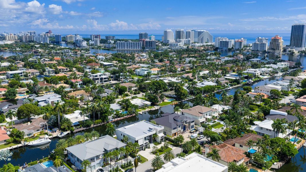A vibrant neighborhood scene showing waterfront homes leading toward the Fort Lauderdale coastline and ocean horizon. A vibrant neighborhood scene showing waterfront homes leading toward the Fort Lauderdale coastline and ocean horizon.