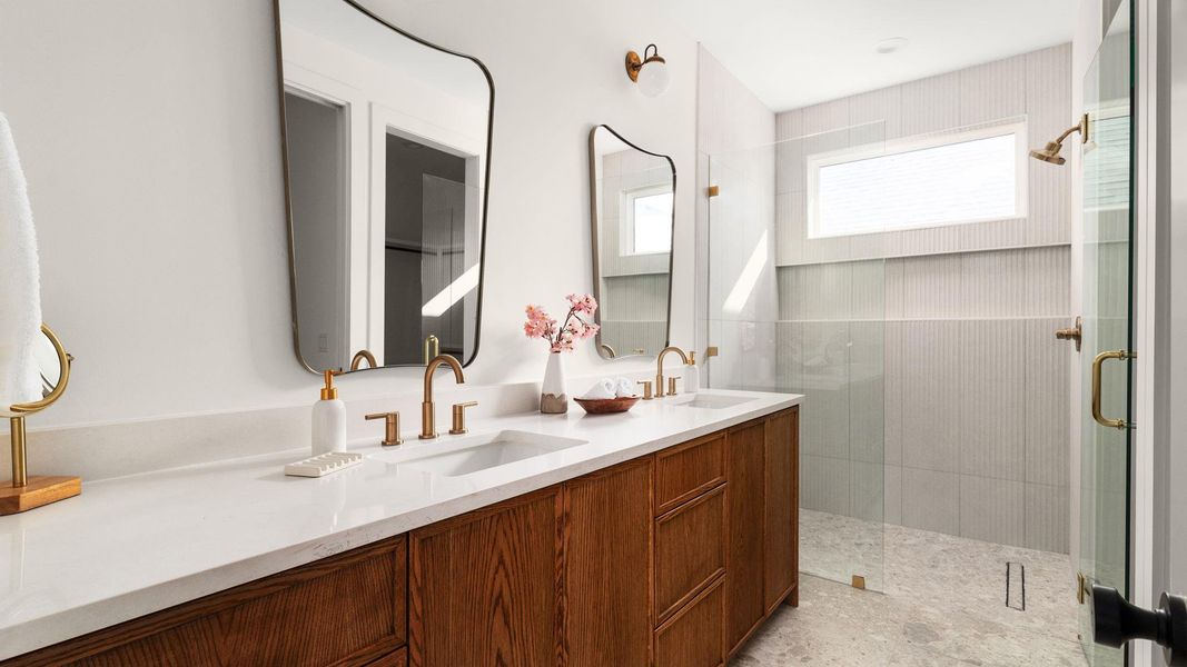 Bathroom featuring double vanity and a shower stall