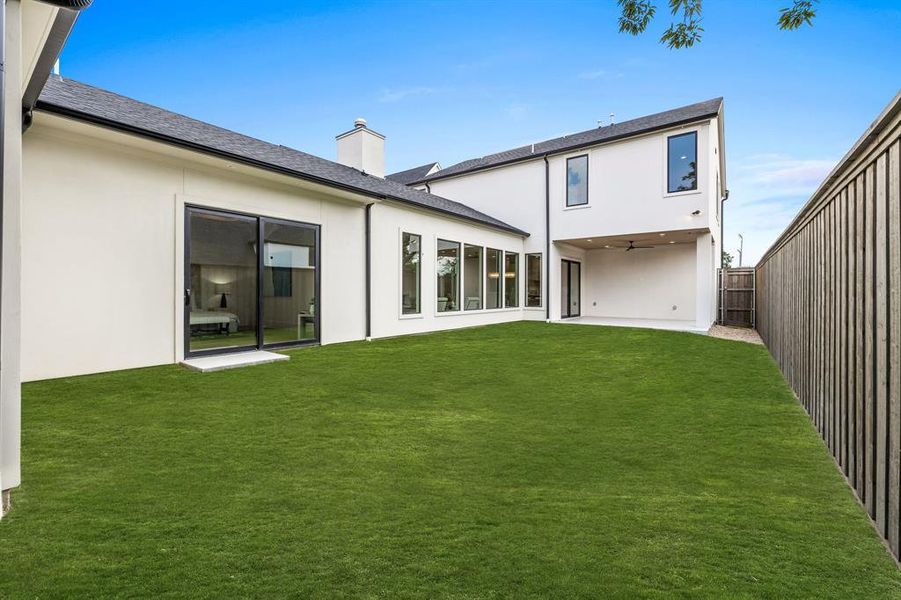 Rear view of house with a patio and a lawn