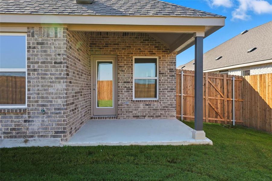 Rear view of house featuring brick siding, a patio, and a gate Rear view of house featuring brick siding, a patio, and a gate
