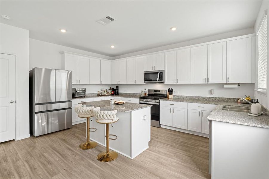 Welcome to the Gourmet Kitchen! The white cabinetry, oversized island, breakfast bar for additional seating and Stainless Steel appliances are just a few of the highlights.