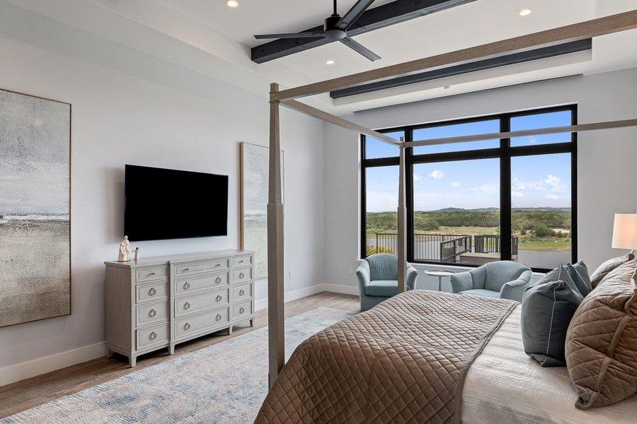 Spacious room featuring a wide window with black framing, wood-finish flooring, a ceiling fan with dark blades, recessed lighting, and decorative ceiling beams