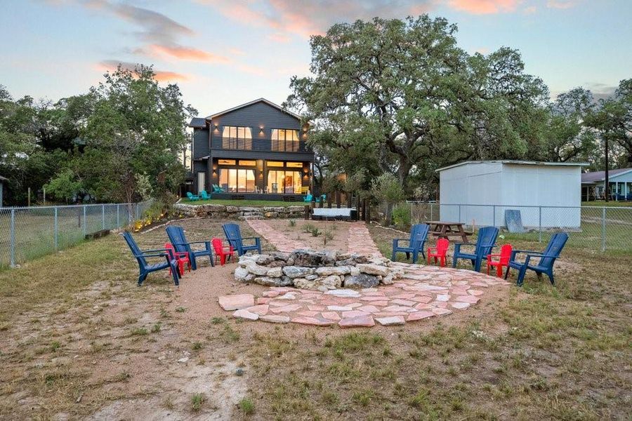 Unwind under Hill Country skies around the custom stone firepit, perfectly positioned in a spacious backyard made for gathering. This Canyon Lake retreat features a large deck, mature oaks, and room to relax or entertain—just steps from the water’s edge