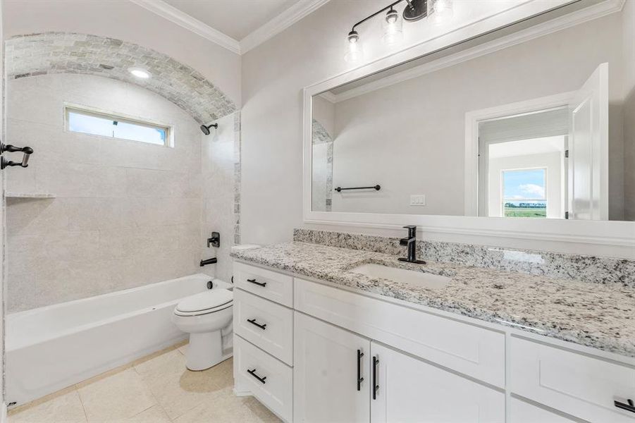 Full bathroom featuring shower / washtub combination, vanity, ornamental molding, and light tile patterned floors