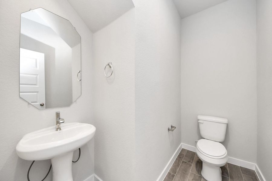 This half bathroom features a stylish pedestal sink, modern hardware, and bright recessed lighting, creating a sleek and inviting space. This half bathroom features a stylish pedestal sink, modern hardware, and bright recessed lighting, creating a sleek and inviting space.