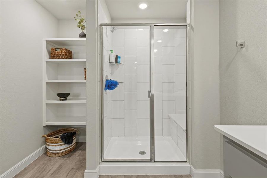 Glass-enclosed shower featuring white subway tile, an integrated shower bench, and a white shower pan Glass-enclosed shower featuring white subway tile, an integrated shower bench, and a white shower pan