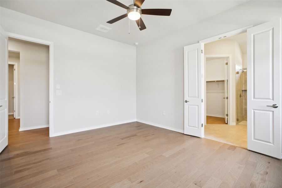Unfurnished bedroom featuring a spacious closet, light wood-type flooring, and a ceiling fan Unfurnished bedroom featuring a spacious closet, light wood-type flooring, and a ceiling fan