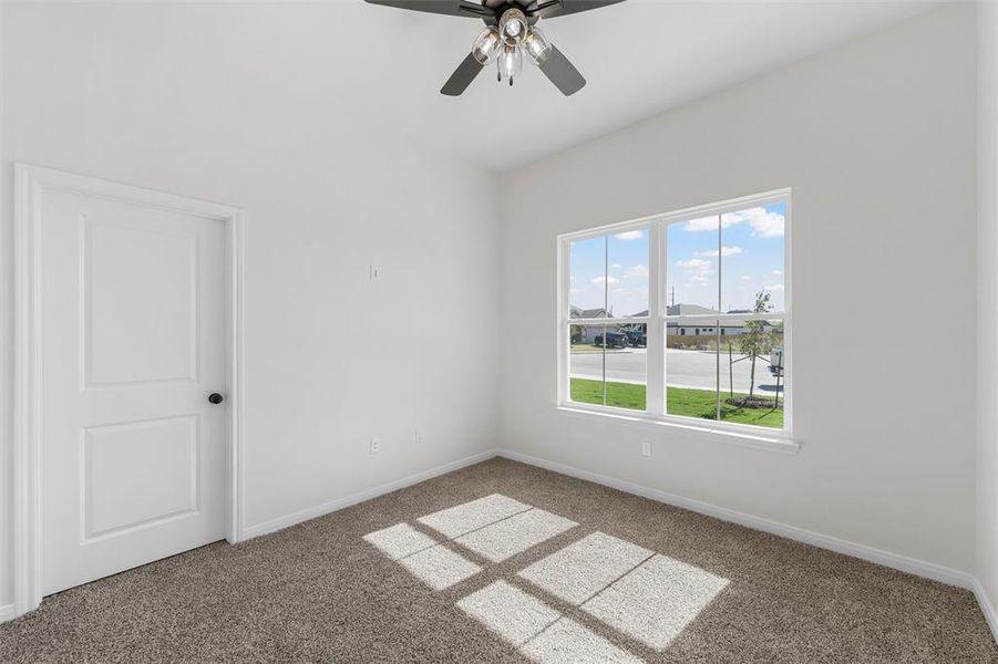 Carpeted empty room with baseboards and ceiling fan