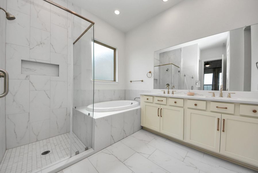 Elegant bathroom featuring a spacious glass-enclosed shower, luxurious soaking tub, and dual vanity with ample storage.
