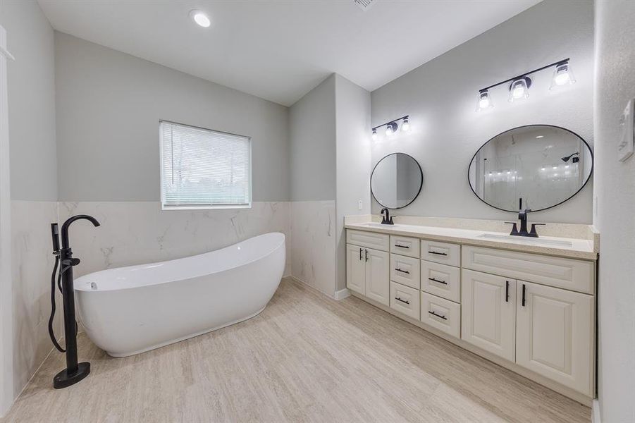 Expansive primary bath with a luxurious soaking tub, dual vanities, and a spacious walk-in shower for ultimate relaxation.