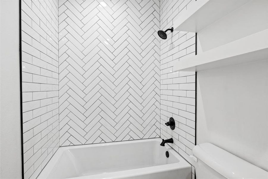 Full bathroom featuring shower / bathtub combination and toilet Full bathroom featuring shower / bathtub combination and toilet