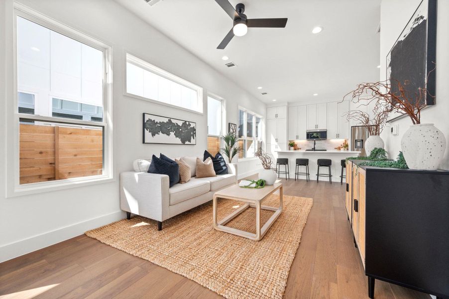 Living area featuring light wood-type flooring, ceiling fan, and recessed lighting