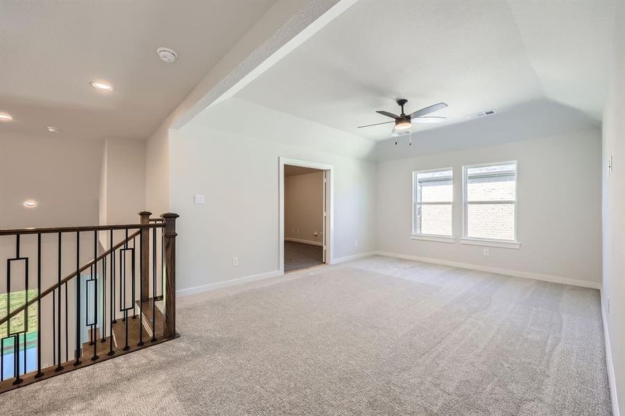 Empty room with ceiling fan and light carpet