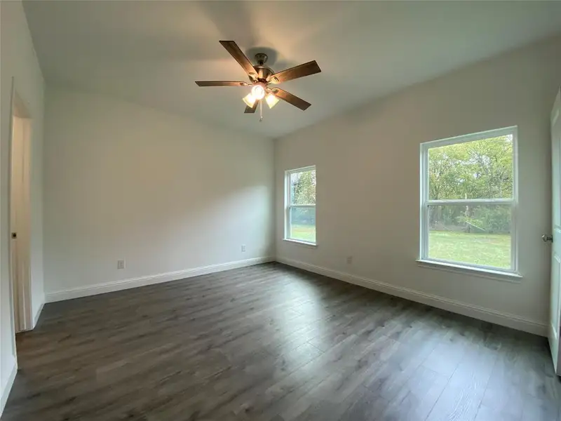 Bedroom featuring dark wood finished floors and a ceiling fan Bedroom featuring dark wood finished floors and a ceiling fan