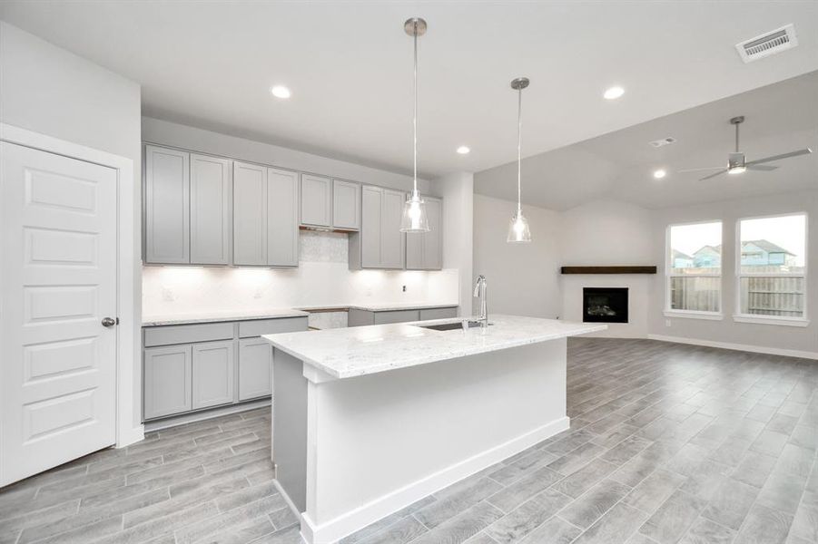 This kitchen is by far any chef’s dream! This spacious kitchen features high ceilings, light slate wood cabinets, granite countertop, SS appliances, modern tile backsplash, recessed & pendant lighting, extended counter space, granite kitchen island with single basin sink. Sample photo of completed home with similar floor plan. As-built interior colors and selections may vary.