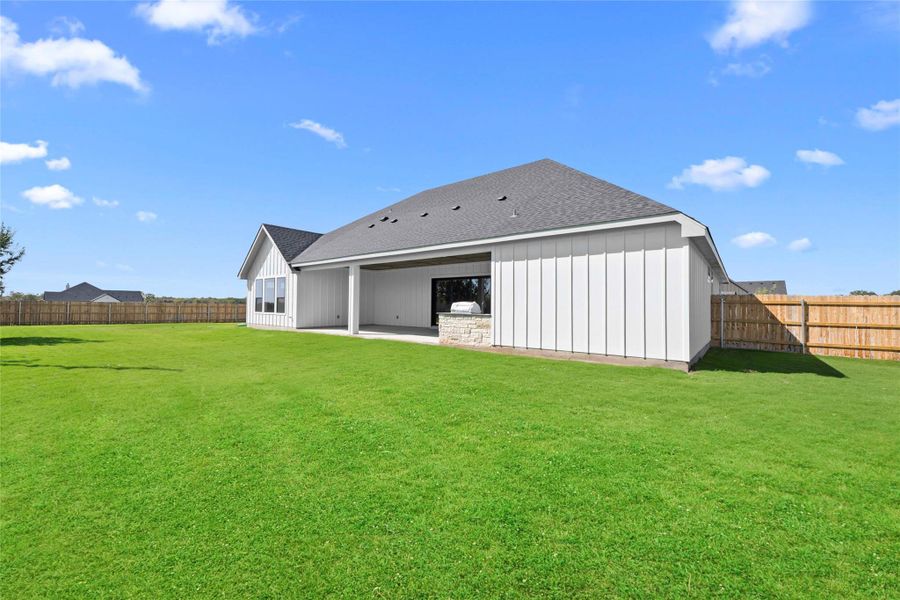 Back of house featuring a shingled roof, a patio area, a fenced backyard, and board and batten siding Back of house featuring a shingled roof, a patio area, a fenced backyard, and board and batten siding