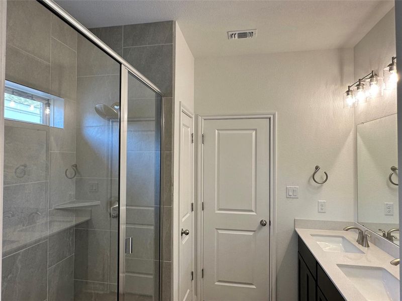 Bathroom with a stall shower and double vanity