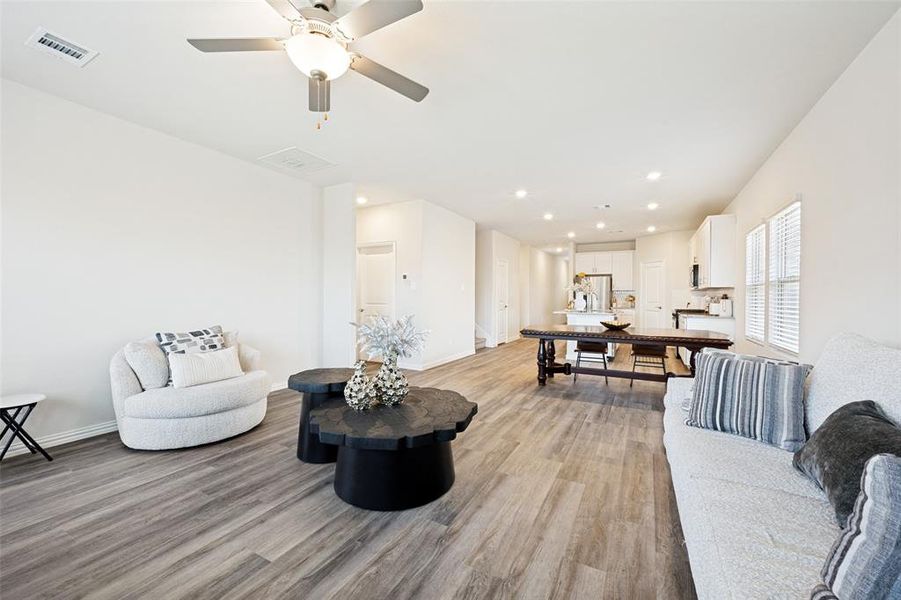 Open-concept living space featuring wood-finish flooring, recessed lighting, and a ceiling fan Open-concept living space featuring wood-finish flooring, recessed lighting, and a ceiling fan