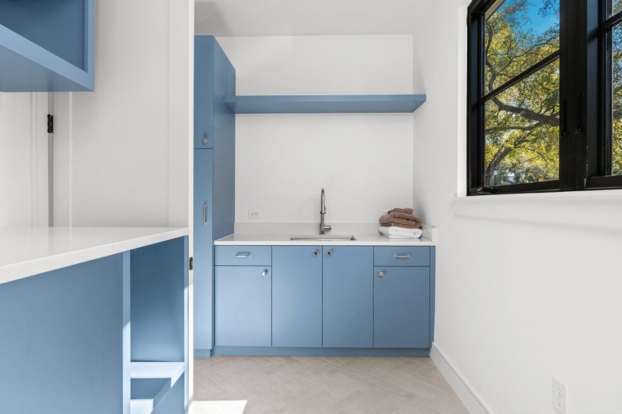 The second floor has its own laundry room with a faucet and plenty of counter space for folding and storage.