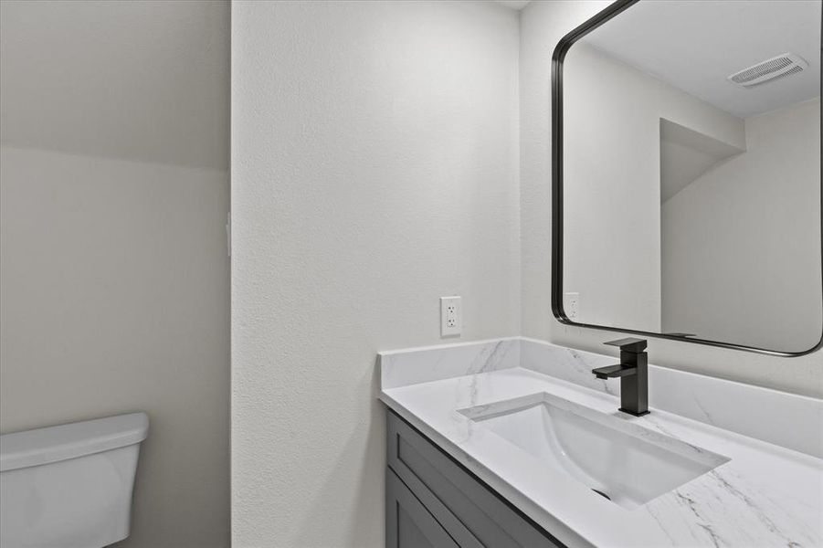 Bathroom featuring vanity and a textured wall