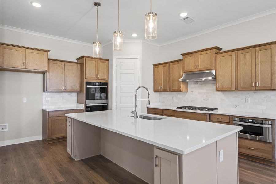 Kitchen featuring tasteful backsplash, large island, crown molding, hanging light fixtures, and recessed lighting