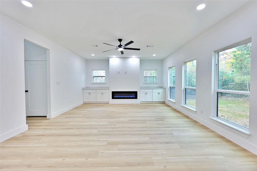 Living room with electric color-changing fireplace and plenty of windows!