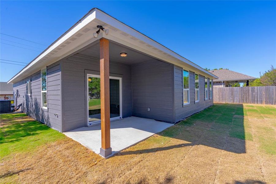 Back of property with a lawn, cooling unit, and a patio