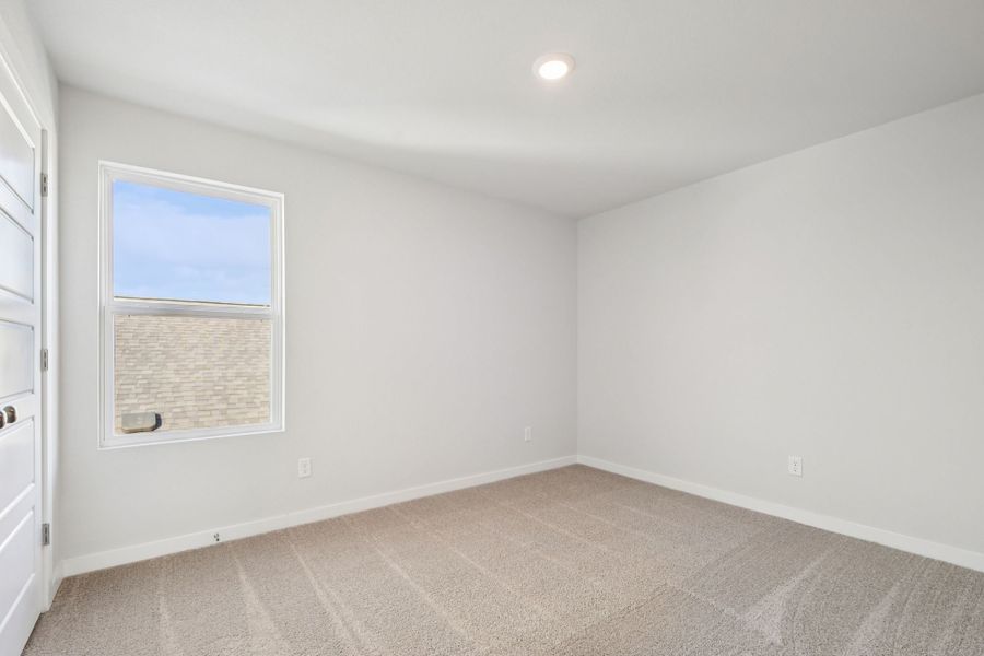 A room with a window and a carpet.